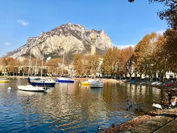 Sailboats moored in lake against sky