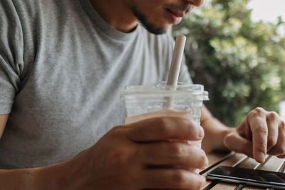 Midsection of man holding drinking glass