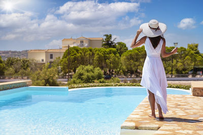 Rear view of woman standing in swimming pool