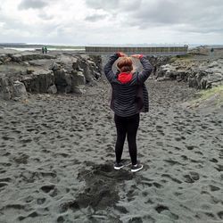 Full length rear view of man standing on beach