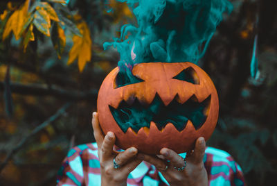 Close-up of hand holding pumpkin during halloween