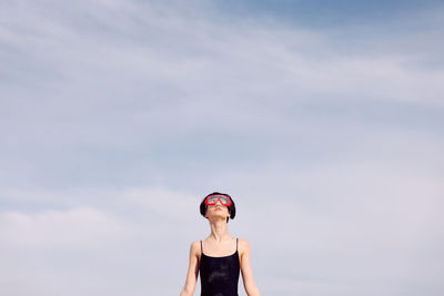 Low angle view of woman standing against sky