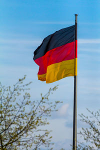 Federal republic of germany, german national flag waving on the blue sky background, de