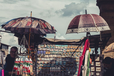 People at market stall against sky