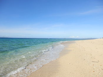 Scenic view of beach against blue sky