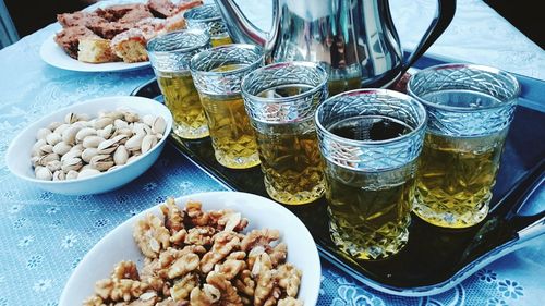 High angle view of beer glasses with nuts served on table