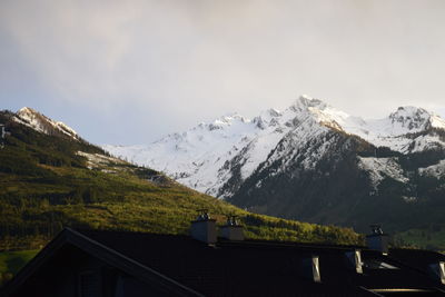 Houses on snowcapped mountain against sky