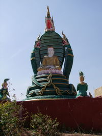 Low angle view of statue against temple against clear sky