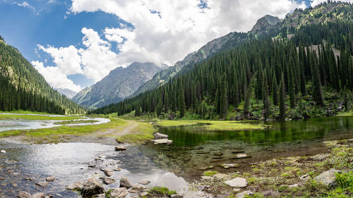 Scenic view of lake and mountains against cloudy sky