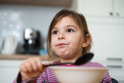 Cute girl eating food while looking away