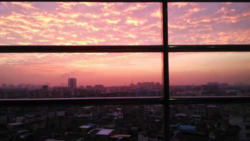 View of cityscape against cloudy sky
