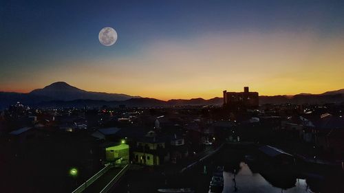 High angle view of illuminated buildings in city at sunset