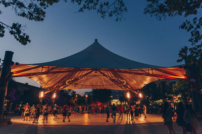 People at town square against clear sky at night