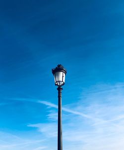 Low angle view of street light against blue sky