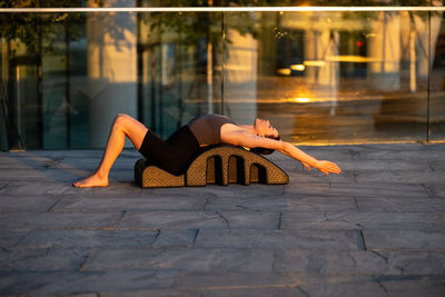 Low section of woman sitting on footpath