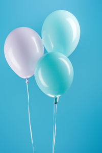 Low angle view of balloons against blue background