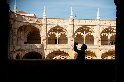 Silhouette of woman in front of building