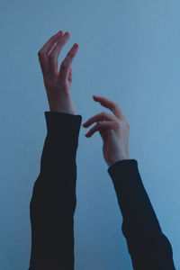 Low angle view of person hand against sky