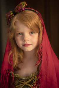 Portrait of cute girl wearing red headscarf