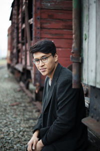 Portrait of young man standing against rusty train