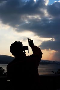 Silhouette of woman in sea at sunset