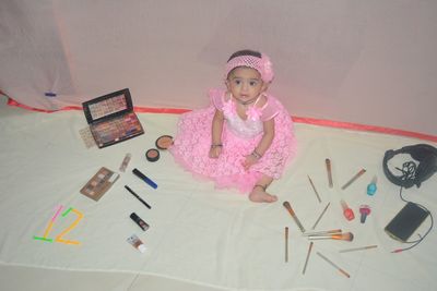 High angle view of cute girl lying on table at home