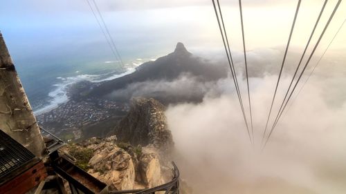 Overhead cable car over mountains against sky