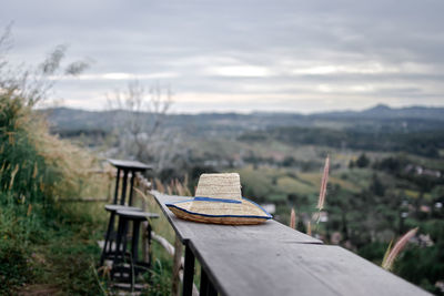 Empty chairs and tables against sky