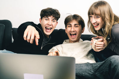 Friends using laptop at home