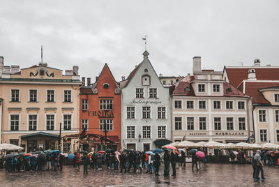 Group of people on building in city against sky