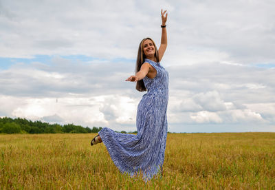 Rear view of woman standing on field against sky