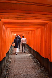 Rear view of men walking on footpath