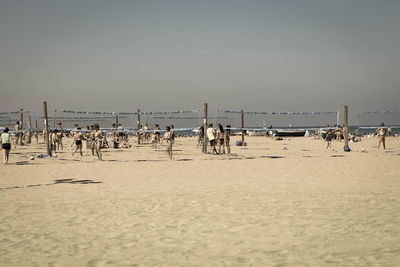 People on beach against clear sky
