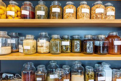 Jars of various kinds of preserved food, herbs, spices, and fruits on shelves