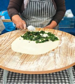 Midsection of woman preparing food on cutting board