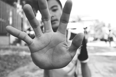 Close-up of man gesturing stop sing outdoors