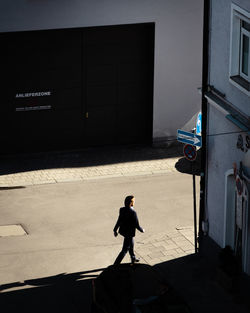 Side view of man walking on street against buildings