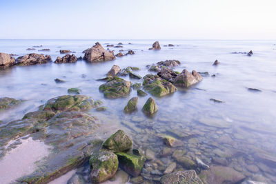 Rocks in sea against sky