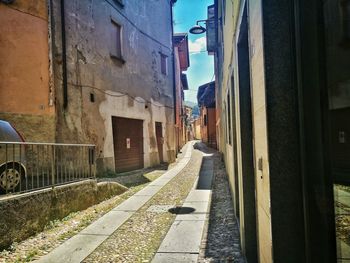 Road amidst buildings against sky