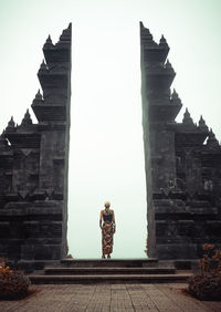 A woman standing at the temple's gate