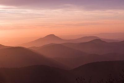 Scenic view of mountain range against sky at sunset