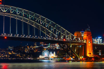 Illuminated bridge over river at night