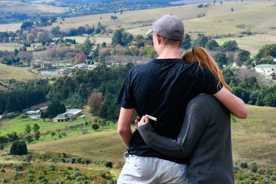 Friends embracing while standing on mountain