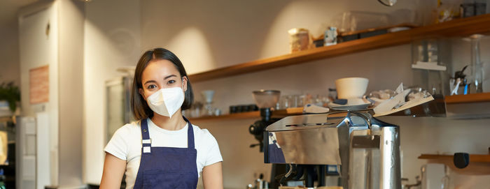 Portrait of young woman standing in factory