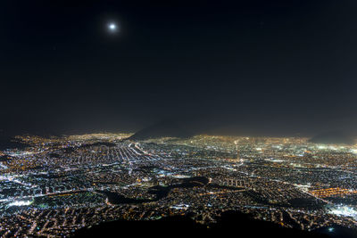 Illuminated cityscape against sky at night