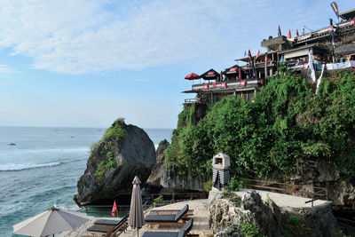 Built structure on beach by sea against sky