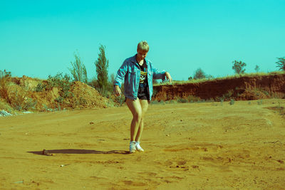 Full length of man running on landscape against clear sky