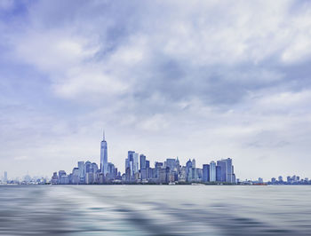 View of buildings in city against cloudy sky