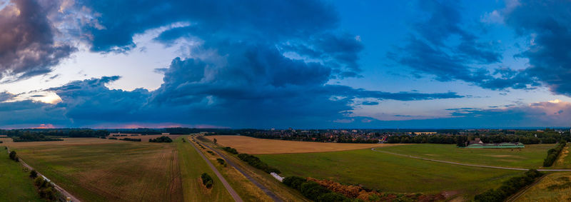 Panoramic view of agricultural field against sky