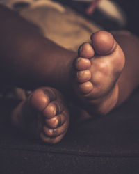 Photograph of an african baby feet in a dark room 